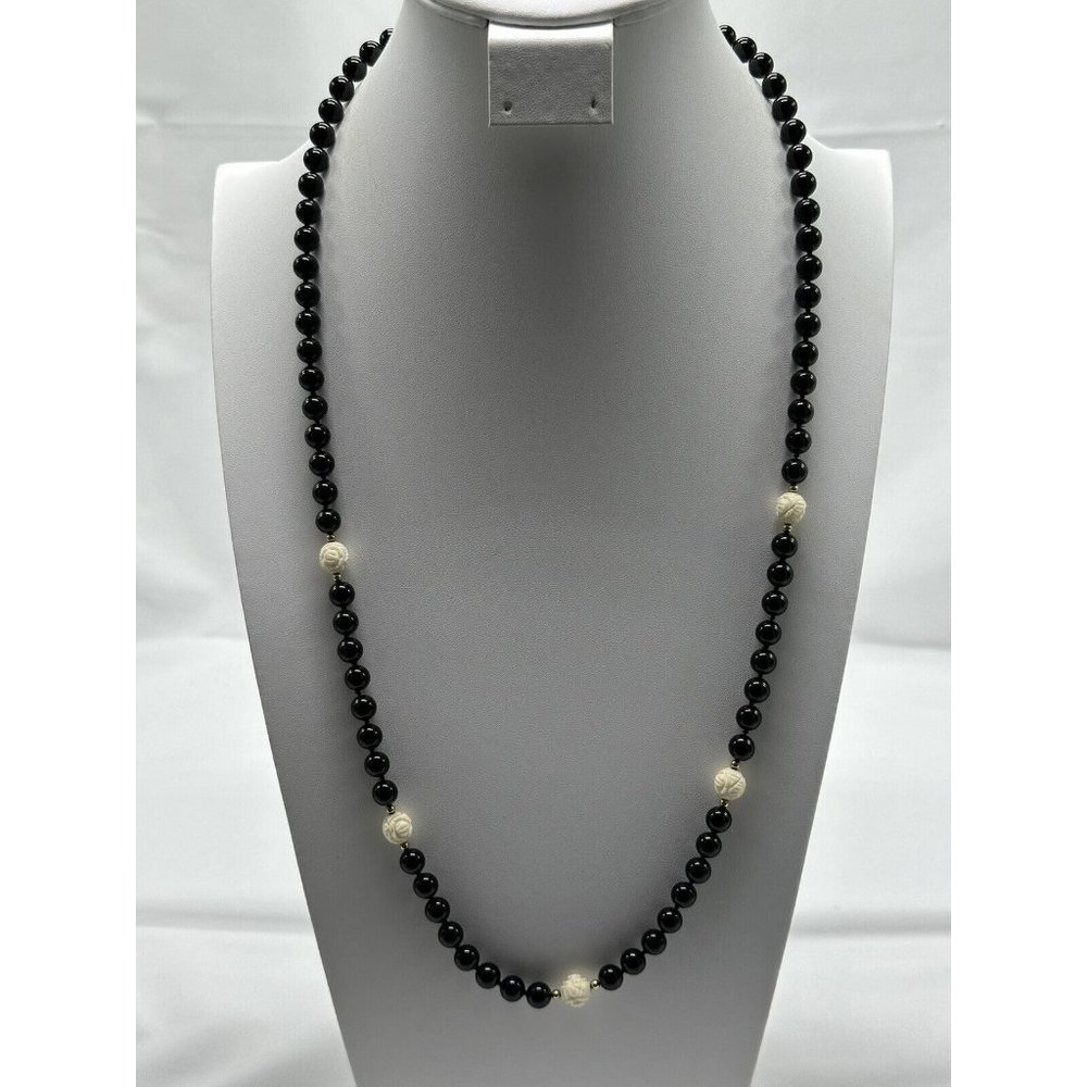 black bead necklace with 5 ivory colored carved beads / goldtone beads between